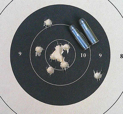 A couple of loaded 44-40 rounds help show the size of the 10-shot group, shot at 50 yards and scoring 98-7X.